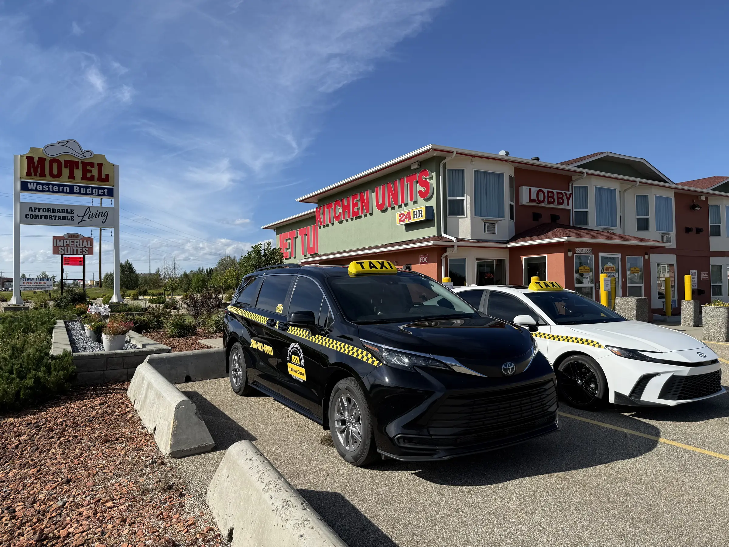 Yellow Cabs Whitecourt taxis parked outside a Whitecourt motel